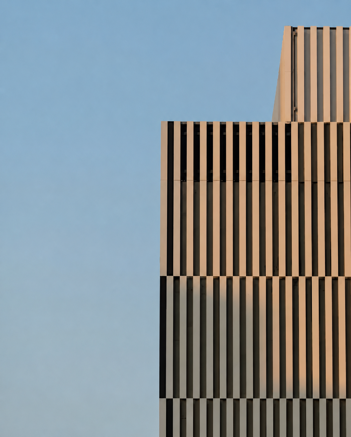 Modern building facade against pale blue sky